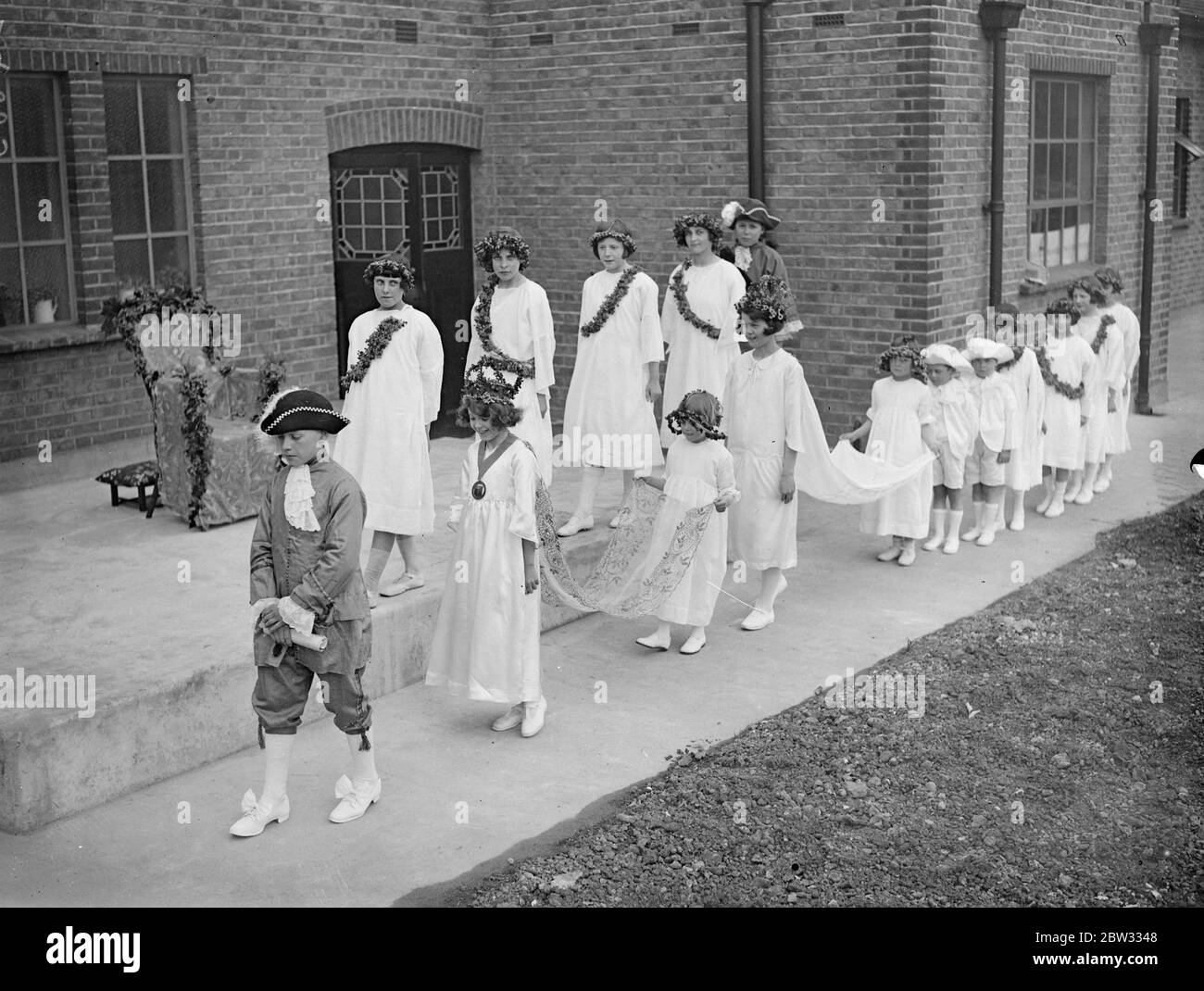 May Queen of Dagenham crowned with ceremony . With full ceremony the May Queen of Dagenham , the great London County Council , housing estate in Essex , Miss Patricia Canewas crowned by her predecessor Miss Betty Biggs at the Osborne Hall , Dagenham , where a special rehearsal of the ceremony took place . The coronation ceremony . 29 April 1932 Stock Photo