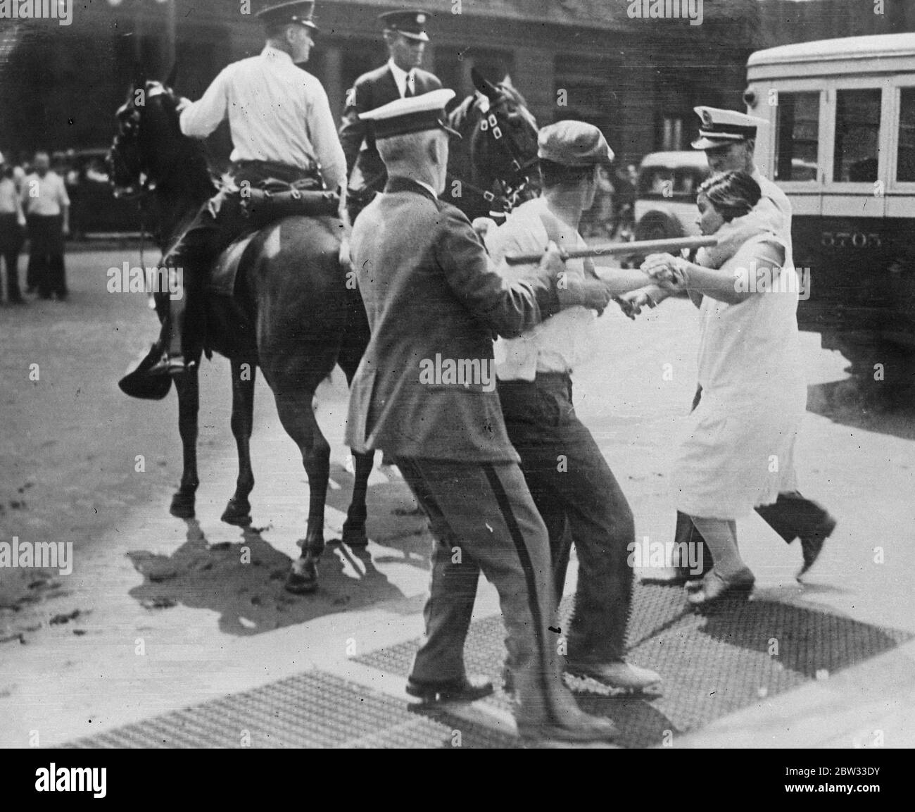 Police make short work of hunger marchers in Philadelphia . Hunger marchers who rioted near the City Hall in Philadelphia , USA were quickly dispelled by police and park guards who brought clubs and fists into play . A girl rioter being forcibly removed during the excitement . 2 September 1932 Stock Photo