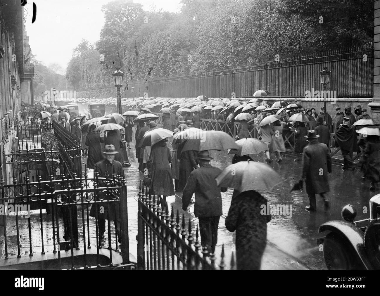 Crowds wait hours in the rain to pay last honours to murdered French president . Crowds lined up for hours waiting to pay their last respect to the late President Doumer of France who was assassinated by a Russian doctor a Russian doctor while attending a book exhibition in Paris , as he lay in state in the Elysee Palace . A view of the crowd waiting to enter the Elysee Palace in Paris to view the body . 9 May 1932 Stock Photo