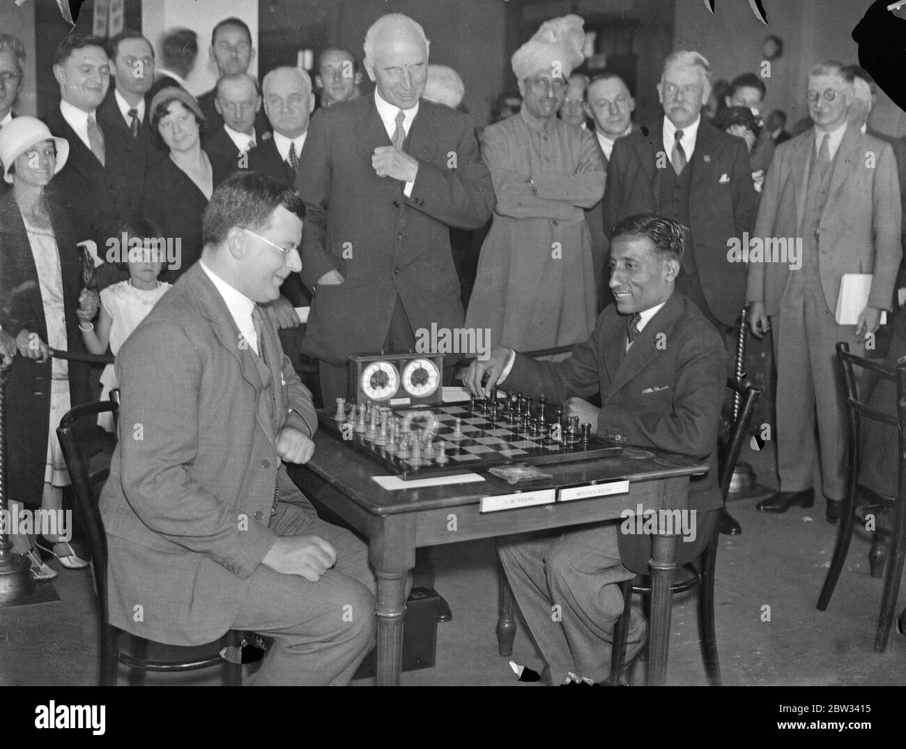 Sir JOhn SImon opens British chess championship in London . Sir John Simon , opened the British chess championships , at the Empire Chess Club , at Whiteleys London . Sir John Simon watching T H Taylor ( left ) and Sultan Khan , playing in the championship tournament . 15 August 1932 . Stock Photo