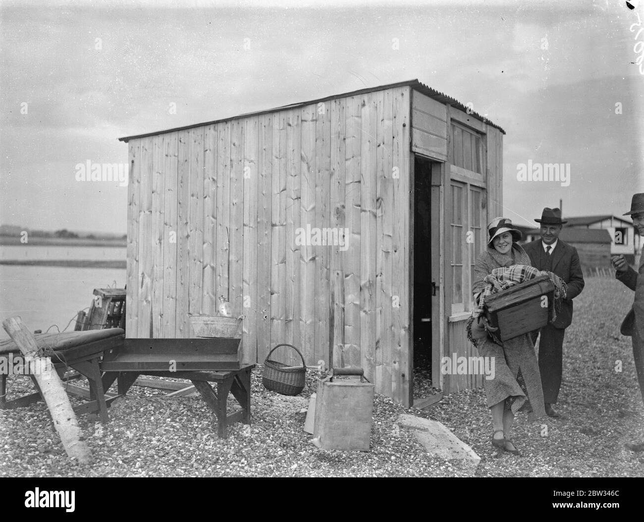 Sea defences broken by flood tide at Winchelsea , bungalows flooded and holidaymakers marooned . The sea defences for a distance of 75 yards along the coast at Winchelsea , Sussex gave way before a flood tide , and a surging torrent of sea water flooded acres of marsh land along the coast , inundating bungalows and marooning holidaymakers . Great efforts are being made to repair the breach before the next tide . 4 September 1932 Stock Photo