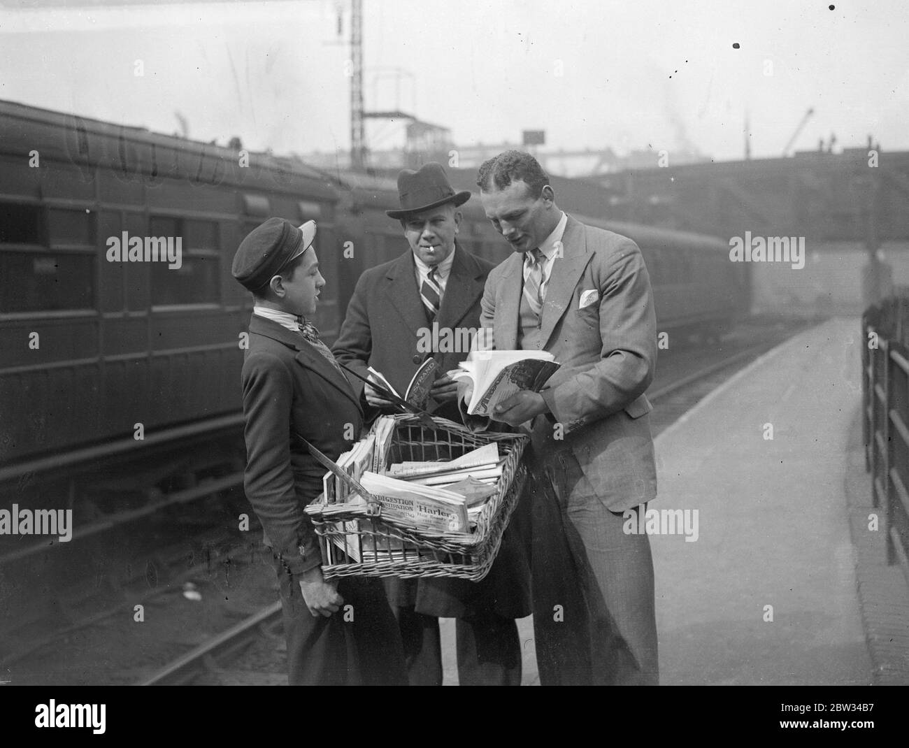 Reggie Meen leaves for Egypt for Championship fight . Reggie Meen the heavyweight boxing champion of Britain left England on the S S Ballarat for Egypt to fight Salar ed Din , the Egyptian Champion in Cairo . Reggie Meen with his trainer Mr Jim Panter buying a magazine at Liverpool Street Station , before leaving for Egypt . 15 April 1932 . Stock Photo