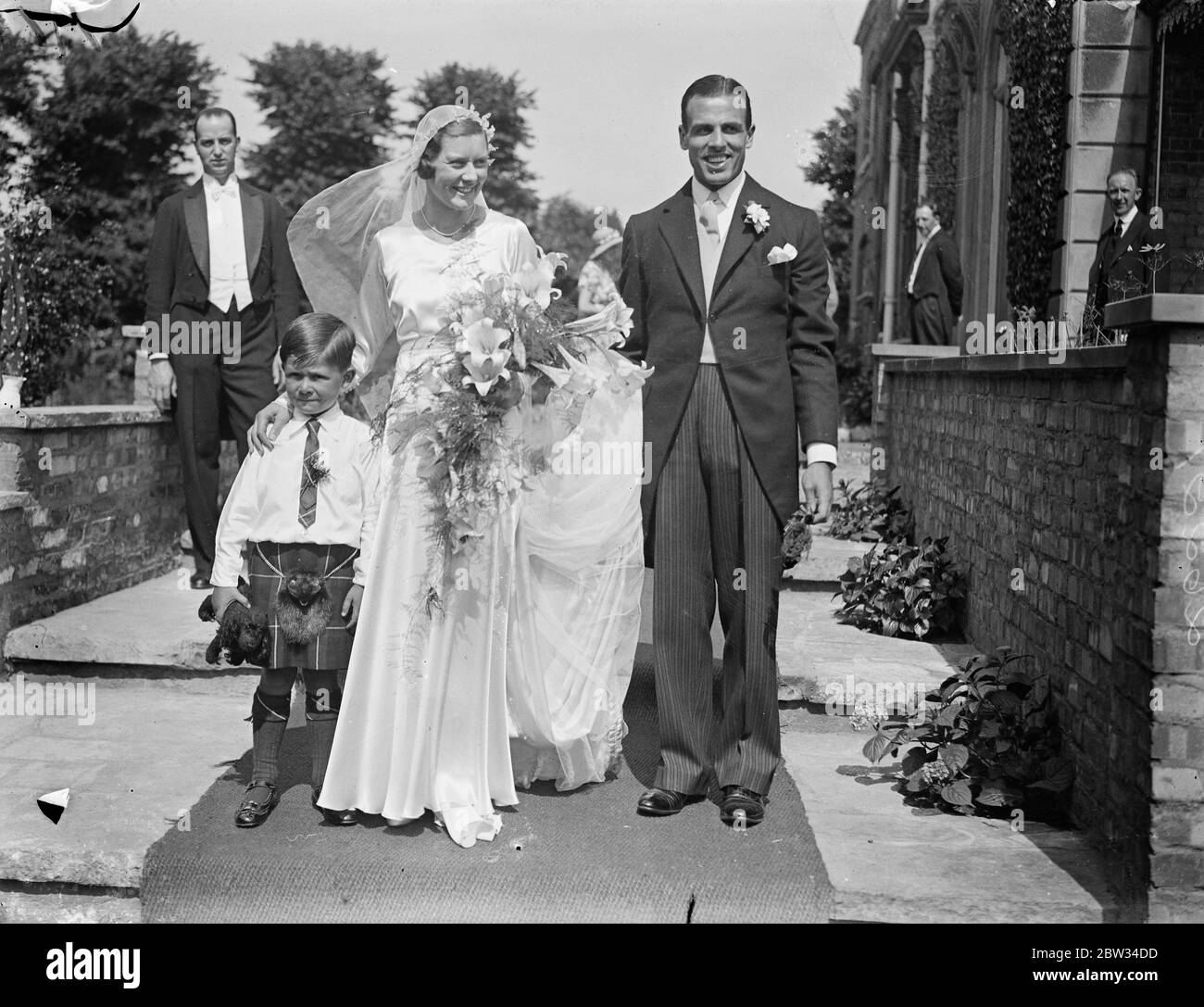 Gwen Sterry marries rugby international at Surbiton . Miss Gwen Sterry , the English lawn tennis player , was married to Mr W M Simmers , the Scottish Rugby International , at St Marks Church , Surbiton , Surrey . A large gathering of tennis players attended the ceremony and Miss Betty Nuthall acted as one of the bridesmaids . The bride and groom with the tiny page Master Hossack . 9 July 1932 Stock Photo