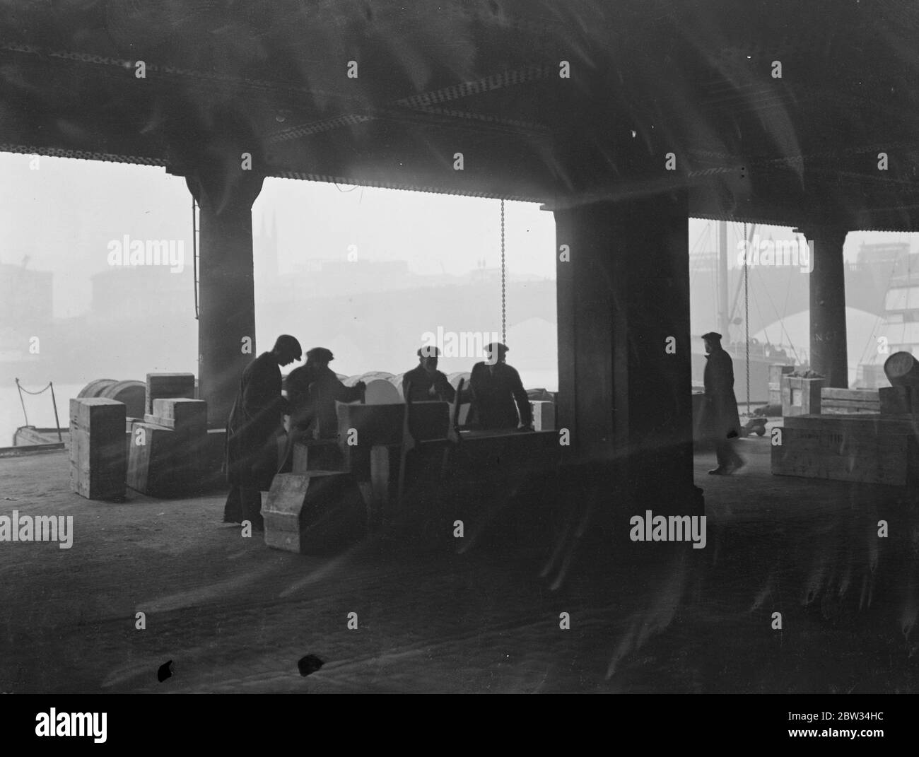 Tons of hardware unloaded in London Docks before imposition of tariff duty . Tons of hardware were unloaded at the London docks beside London bridge in time to evade the imposition of the 10 percent tariff duty which comes into operation on Tuesday . Goods being unloaded in the pool of London at London bridge . 29 February 1932 Stock Photo
