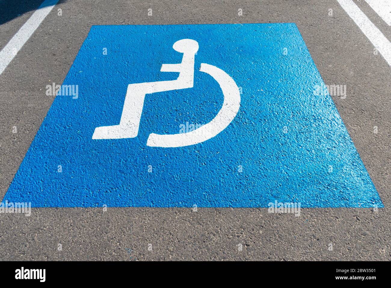 Parking lot with painted handicapped symbol of wheelchair on asphalt, parking spaces for disabled visitors. Empty disabled parking space Stock Photo