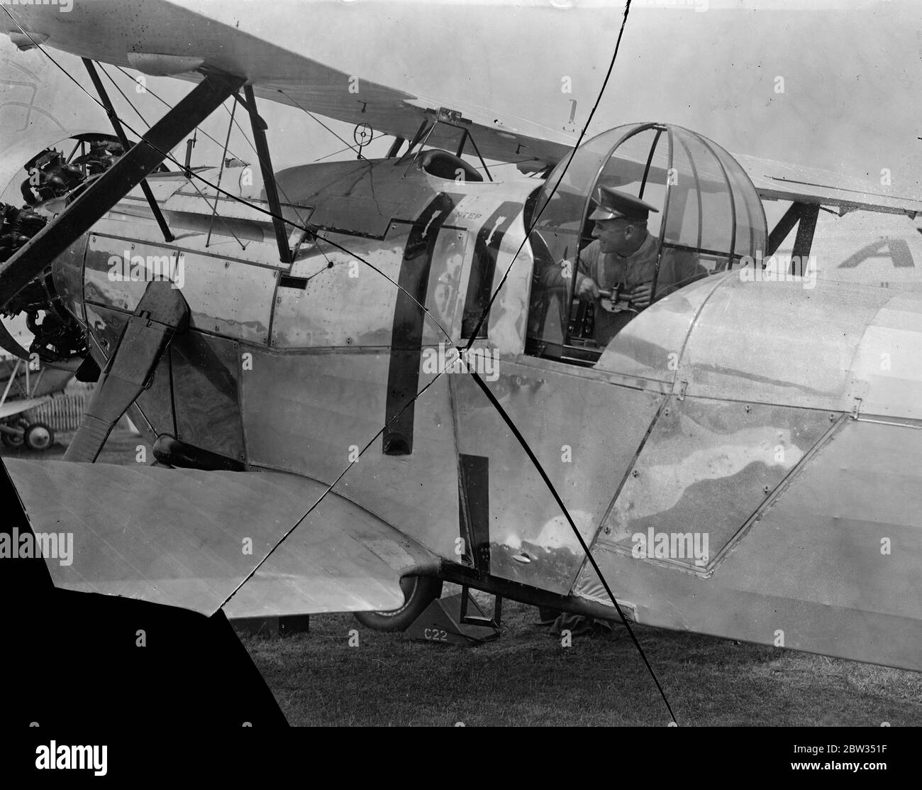 Cages for Air Force gunners . An innovation seen at the Royal Air Force Pageant at Hendon is a wind proof cage covering the gunners cockpit on aircraft . A gunner in his cage at Hendon Aerodrome during the Pageant rehearsal . 23 June 1932 Stock Photo