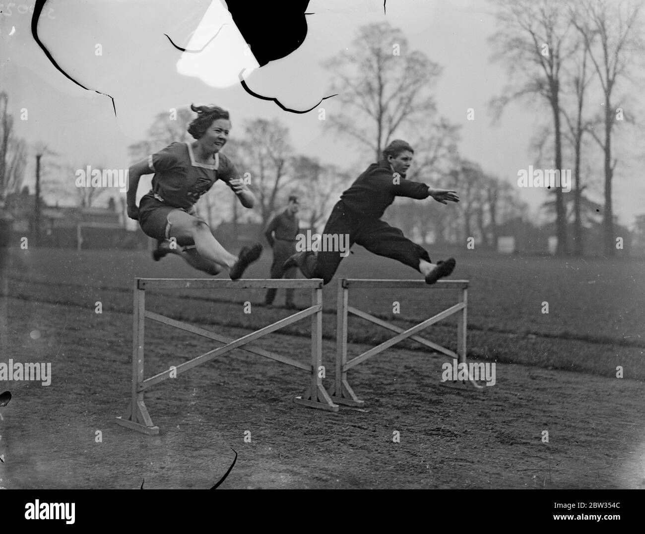 Champion woman hurdler practices at Mitcham . Miss Kathleen Tiffin , the champion woman hurdler , with Miss Beatrice Proctor , were out at Mitcham , Surrey , practicig for the coming summer championship . Miss Beatrice Proctor ( nearest camera ) and Miss Kathleen Tiffin in fine action taking a hurdle while training at Mitcham , Surrey . 26 February 1933 Stock Photo