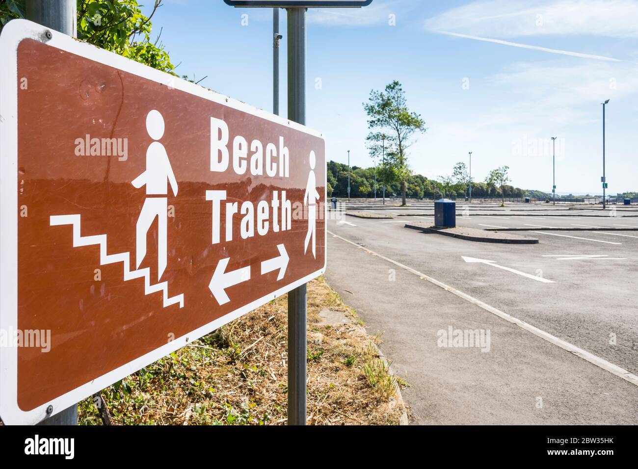 A sign points the way to the beach from an empty car park at Barry Island on a sunny Spring Bank holiday afternoon during the 2020 coronavirus crises. Stock Photo