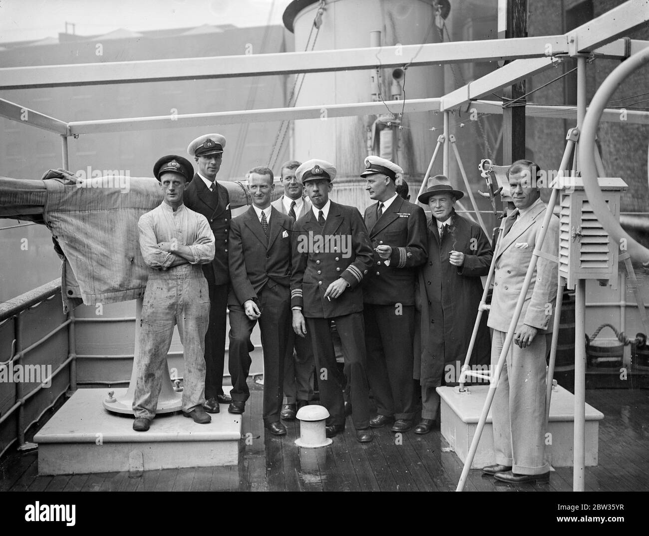 The Royal research ship ,  Discovery II  arrived at St Catherine 's Dock , London , after her nineteen months in the Antarctic . Her Captain , Commander W M Carey , ( Royal Navy retired ) was lost overboard off Ushant on the return voyage . Photo shows , left to right ; The crew with Mr D John the senior scientist , and Lieut A L Nelson , the commander of the Discovery on arrival . 5 May 1933 Stock Photo