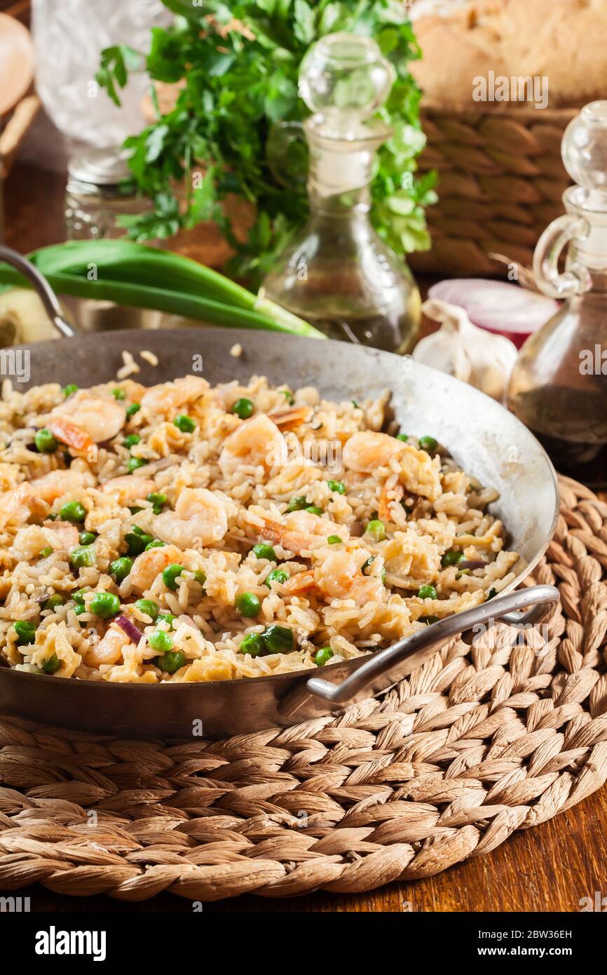 Fried rice with shrimp and vegetables on a frying pan. Popular chinese ...