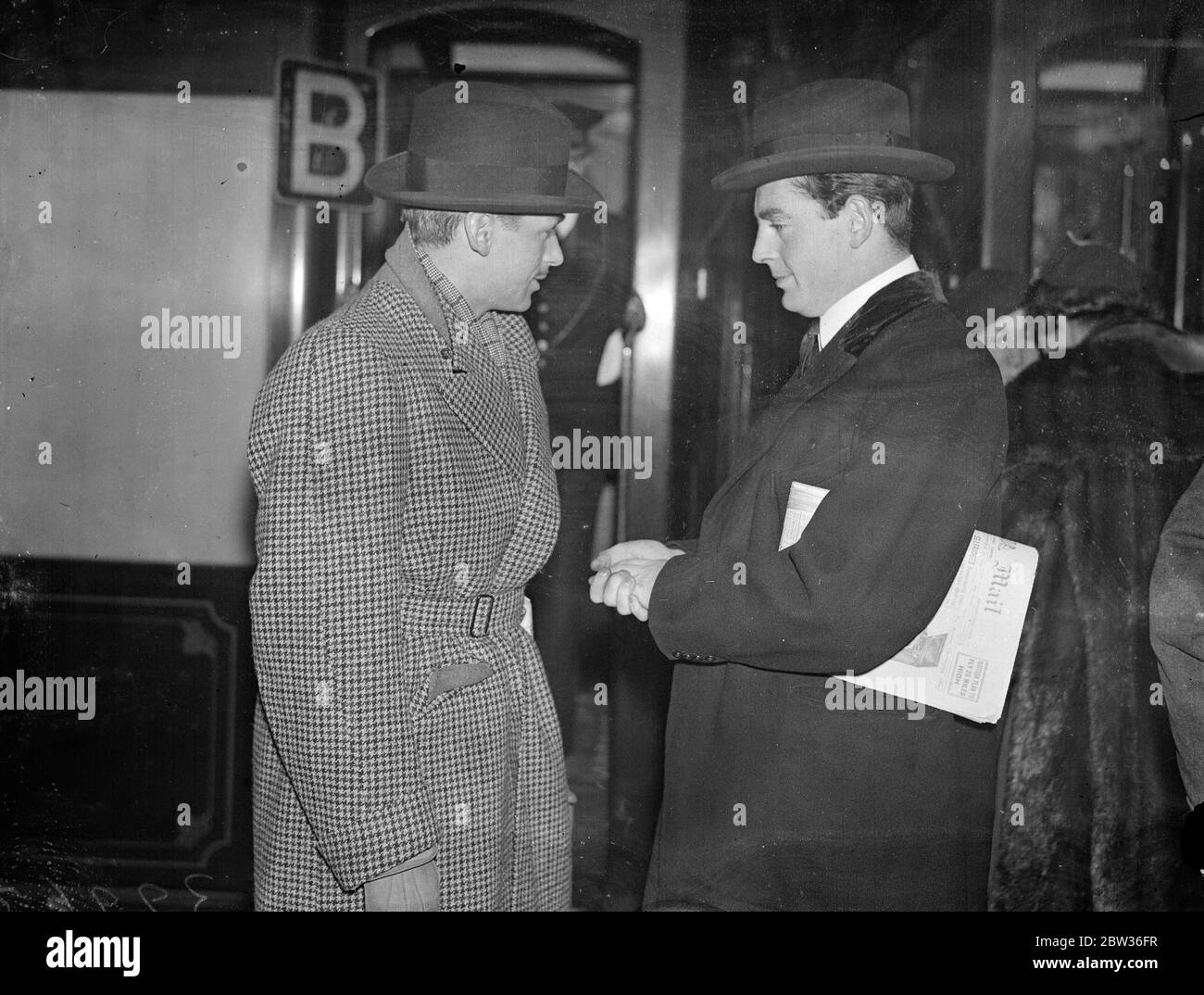 Douglas Fairbanks junior leaves for Hollywood after lightning decision . A few hours after making his decision to go , Mr Douglas Fairbanks , Junior , left Waterloo Station , London , on the Bremen boat boat train , for Hollywood . The lightning departure was the result of ' an ideal starring part ' being offered to him by an American film company . Mr Fairbanks will be back in London January . Photo shows , Mr Douglas Fairbanks , Junior talking with the Earl of Warwick at Waterloo . 29 November 1933 Stock Photo