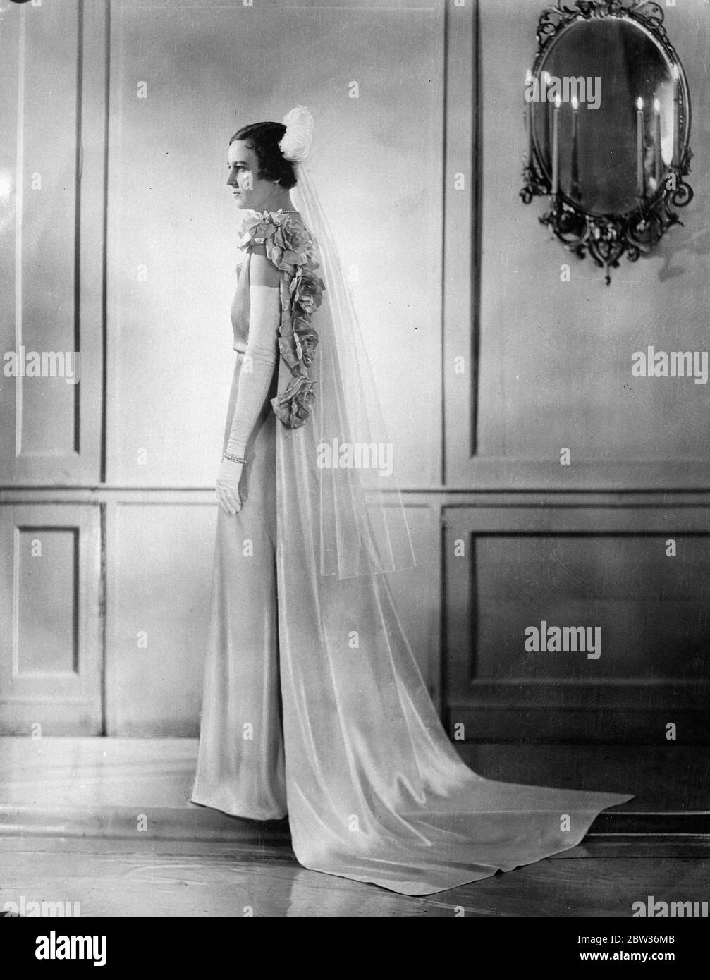 Daughter of American Ambassador to London presented at Court . Miss Henrietta Worth Bingham , daughter of the American Ambassador to London , wearing the gown in which she was presented at the last Royal Court of the Season .The gown is in rich , rose petal , crinkled crepe satin , cut on graceful lines clinging to the figure . The beauty of the gown lies in its extreme simplicity . The cowl bodice is cut rather rather high at the front draping to a deep V at the back of the waist . The train is of rose petal satin , trimmed with satin roses to tone . Stock Photo