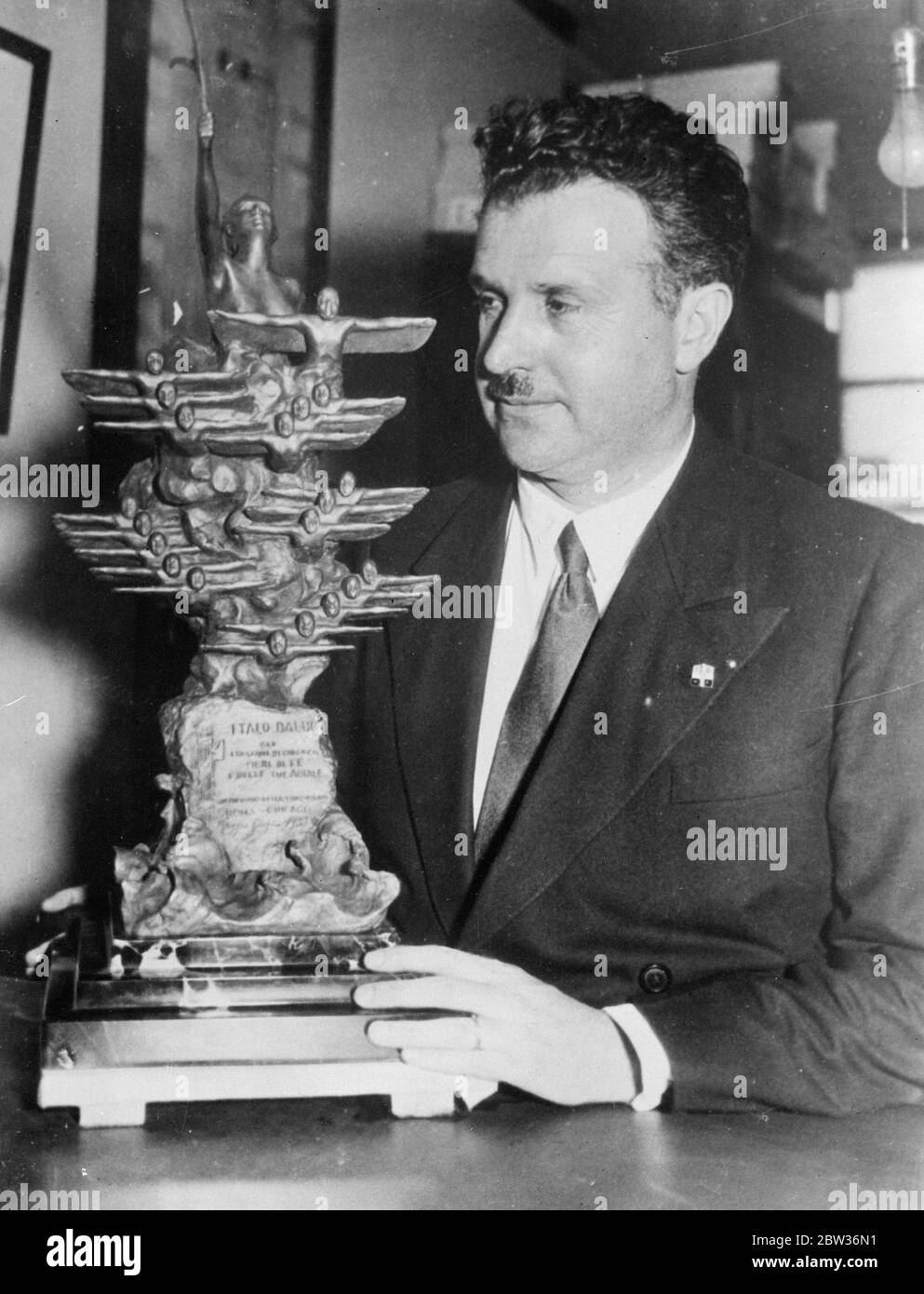 Chicago Italians trophy for General Balbo after leading trans Atlantic flight . Italians resident in Chicago are to present a silver trophy to General Balbo , the Italian Air Minister when he arrives with the fleet of 24 Savoia - Marchetti SM.55X trans - Atlantic seaplanes after the greatest formation flight ever attempted . Photo shows ; Dr Guiseppe Castruccio , the Italian Consul in Chicago , with the trophy which the Italians in the city are to present to General Balbo . 30 June 1933 Stock Photo
