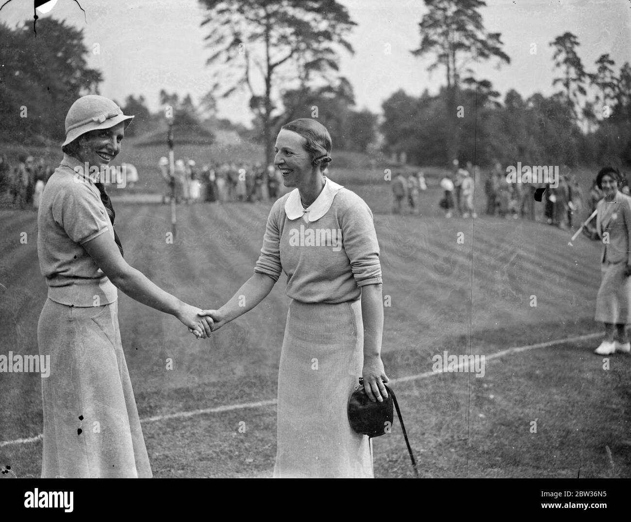 British women golfers defeat French women in international match . A team of British women golfers defeated a French team on the St George ' s Hill course at Weybridge , Surrey . Photo shows ; Madame P Munier ( right ) being congratulated by Miss Diana Fishwick after she had won by one up . 29 June 1933 Stock Photo