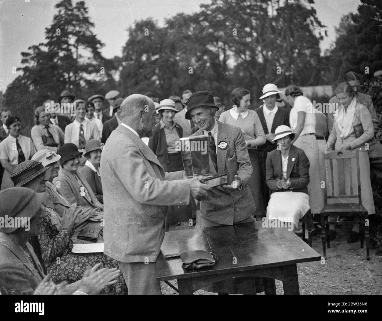 British women golfers defeat French women in international match . A team of British women golfers defeated a French team on the St George ' s Hill course at Weybridge , Surrey . Photo shows ; Mrs P Hodson , the British captain , being presented with the cup . 29 June 1933 Stock Photo