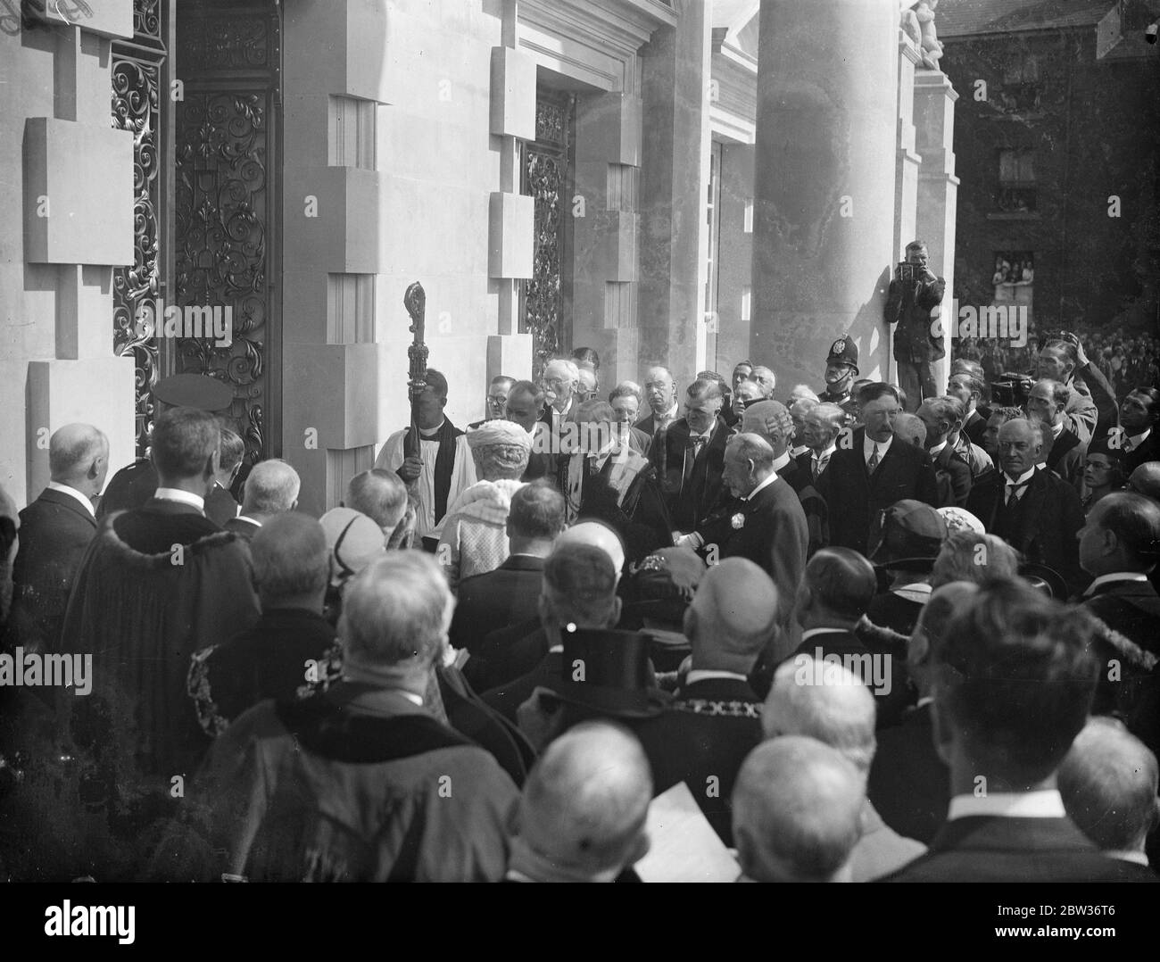 The King and Queen open great new civic hall at Leeds . Photo shows ; King George and Queen Mary enter the new Town Hall through the crowd of officials . 23 August 1933 Stock Photo
