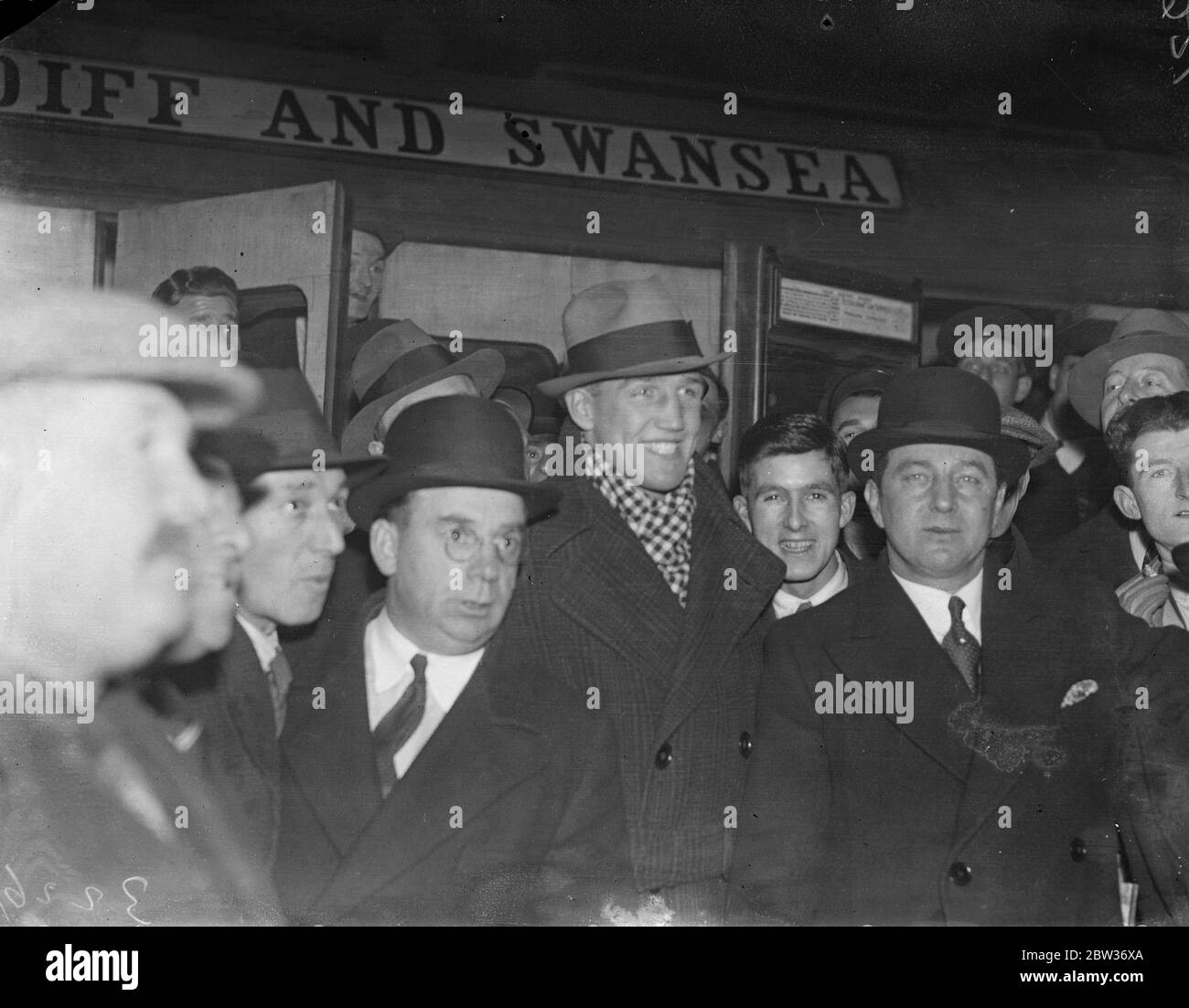 Enormous crowd welcomes Jack Petersen on arrival in London from Cardiff for fight with Len Harvey . An enormous crowd gathered at Paddington Station , London to welcome Jack Petersen on his arrival from Cardiff for his fight with Len Harvey at the Royal Albert Hall , London , tomoorow night . Photo shows ; Jack Petersen ( centre ) surrounded by admirers on arrival at Paddington . 29 November 1933 Stock Photo