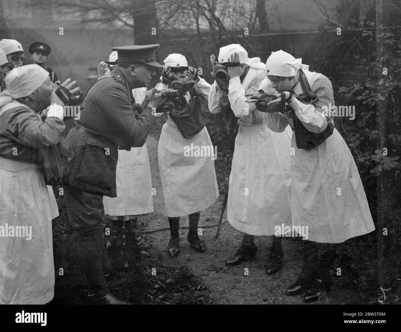 Training to combat air attacks in war . Nurses of the Camberwell branch of the Voluntary Aid Detachment are training to combat poison gas attacks in time of war , thus following the lead of women all over the continent . Wearing gas masks they demonstrated the latest measures and speed with which these can be brought into use in an emergency . Photo shows ; VAD ' s donning gas masks under the guidance of an officer at Camberwell . 4 December 1933 Stock Photo