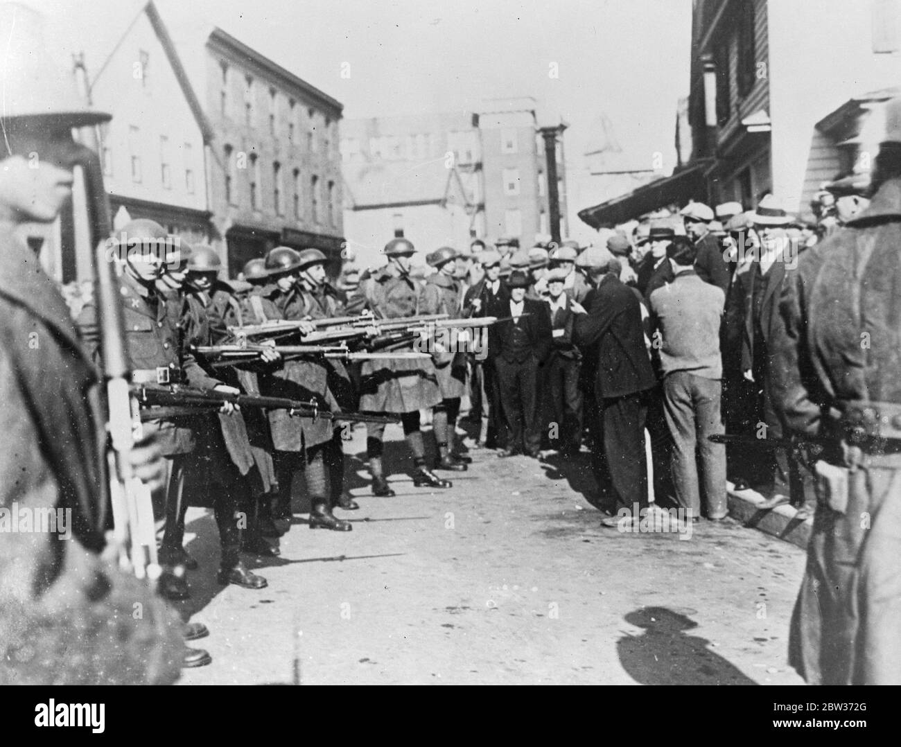 A mob using improvised rams battered a way into gaol in San Jose , California to remove kidnappers John M Holmes and Thomas H Thurmone - tear gas hovers over the building in centre of picture Photo shows ; Soldiers with guns keeping the mob under control . 6 December 1933 Stock Photo