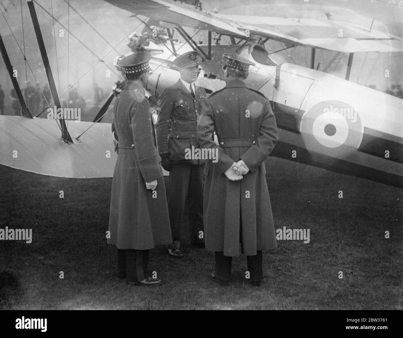 RAF plane down in Hyde Park . A Royal Air Force aeroplane landed in Hyde Park , London , after narrowly missing Marble Arch and trees that were in the path of the plane . The machine was being piloted by Pilot Officer Smith . Photo shows ; Pilot Officer Smith talking to Officers of the Guards . 11 December 1933 Stock Photo