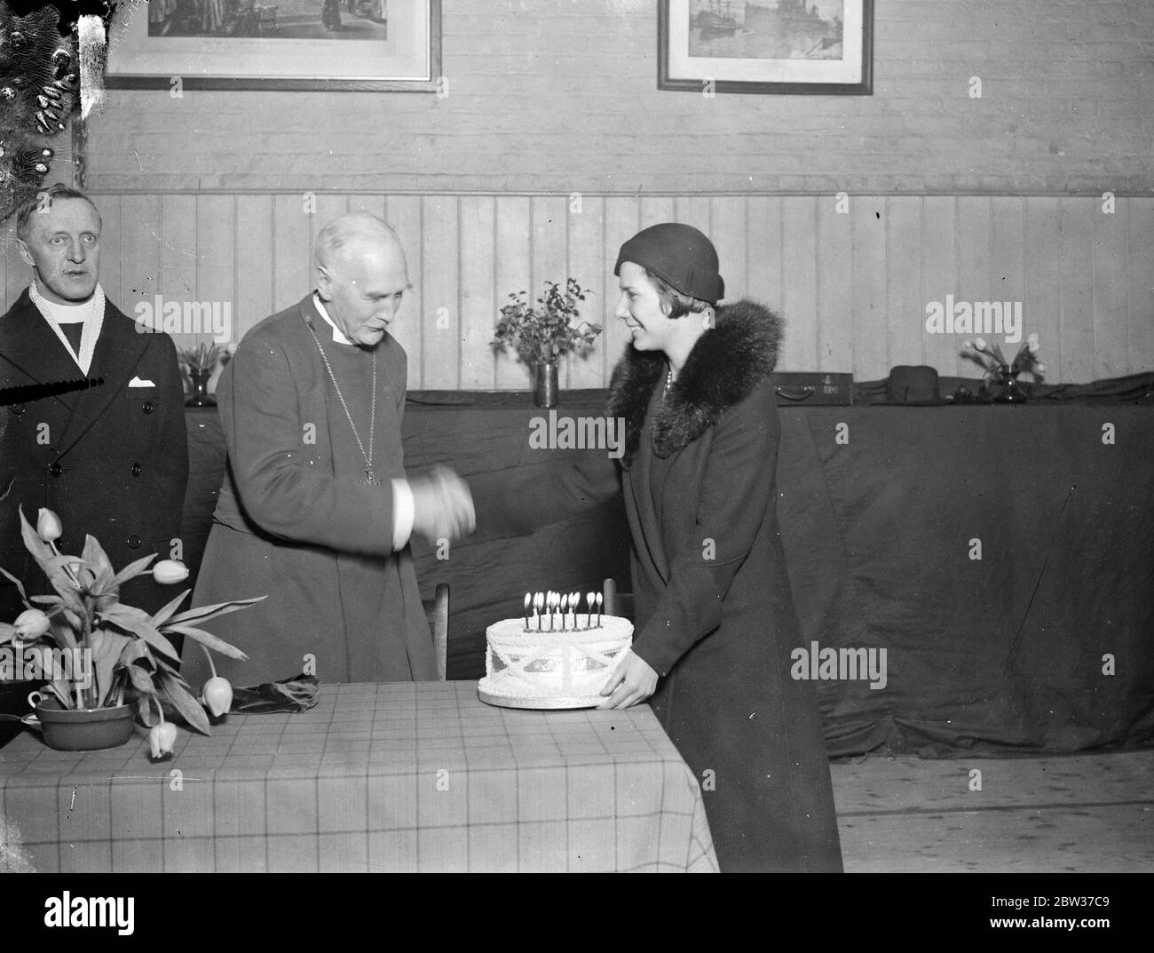 Bishop of London presented with birthday cake . The Bishop of London was presented with a birthday cake in celebration of his 74th birthday when he conducted the centenary service at the church of St John the Evangelist at Paddington , London . The presentation was made by Miss Muriel Closier who celebrated her seventeenth birthday the same day . Photo shows , Miss Muriel Closier presenting the birthday cake to the Bishop of London . 27 January 1932 Stock Photo