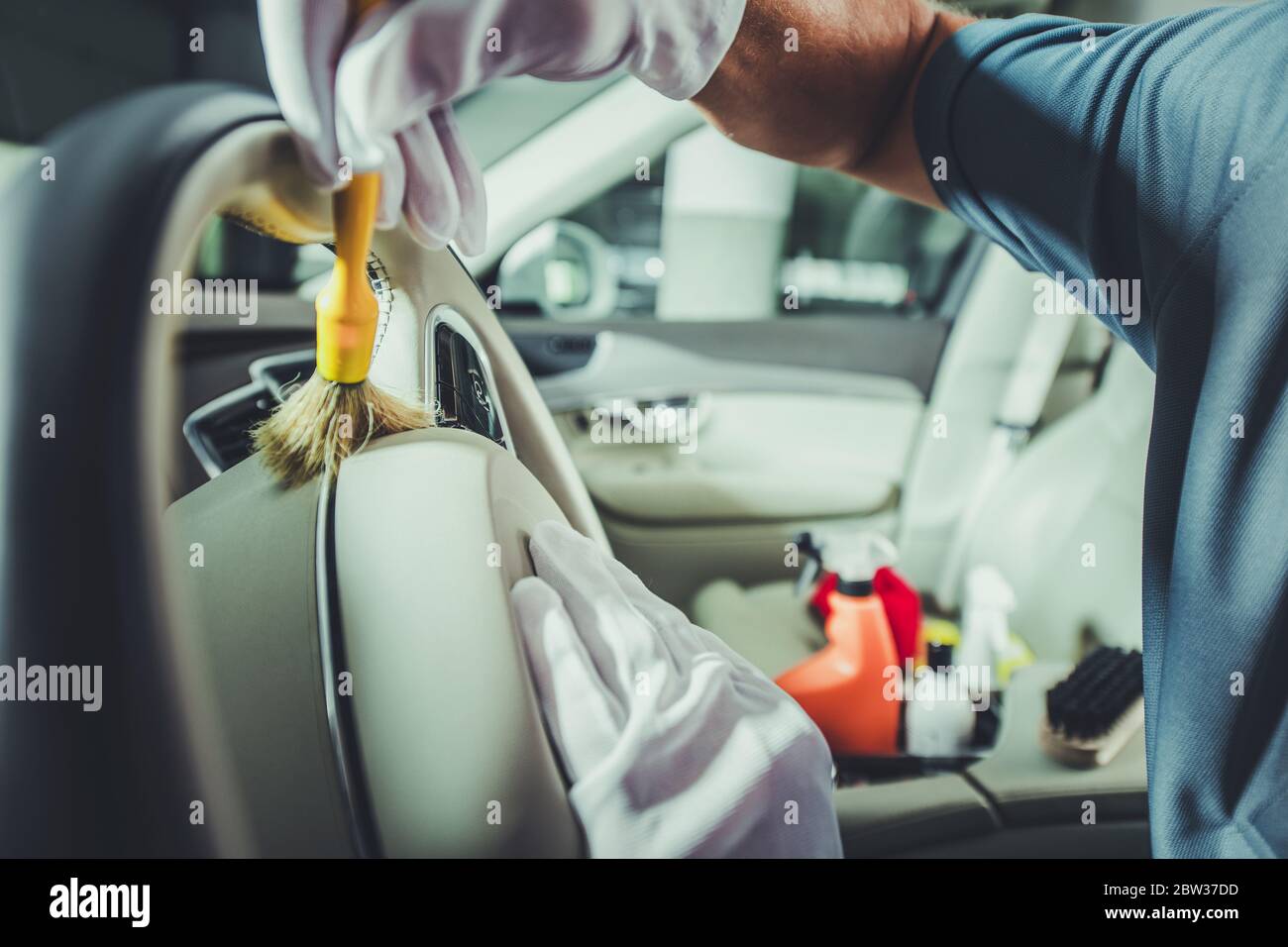 Car interior care services. A plastic cleaner and a rag in the cleaner's  hand. Cleaning of the car interior. Cleaning company Stock Photo - Alamy