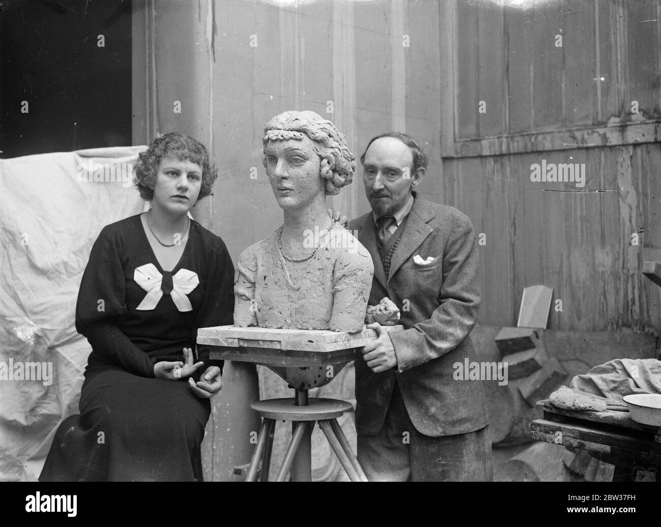 His finest work after six months of idleness . Described by the sculptor as the finest work he has ever done , Mr Frank Dobson is at work on o a portrait bust of Miss Peggy Salaman , the famous airwoman , at his London studio . this is the first work Mr Dobson has attempted since he left hospital where for six months he received treatment for a broken shoulder . He is wondering if the enforced idleness has enabled him to surpass his previous artistic efforts . Miss Salaman holds the record for a flight over the Empire route from England to the Cape . Photo shows , Miss Peggy Salaman sitting to Stock Photo