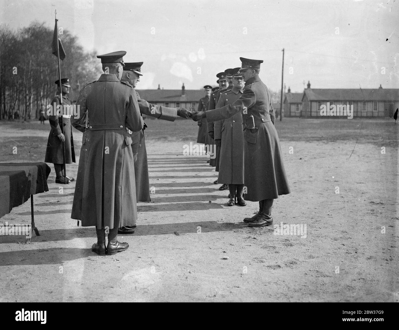 St Patrick ' s day shamrock for Irish Guard . The ceremony of presenting shamrock to the Irish Guards was carried out on St Patrick ' s day at Pirbright Camp , Brookwood , Surrey . Photo shows , Colonel L M Gregson , O B E , distributing the shamrock to officers of the 1st Battalion Irish Guards . 17 March 1934 Stock Photo