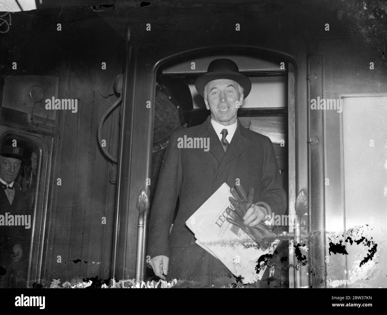Sir John Simon leaves for Geneva . Sir John Simon , the Forign Secretary , left London for Geneva to attend the Disarmament Conference . Phot shows Sir John Simon buying a paper at the bookstall on Victoria station before his departure from London . 17 January 1934 Stock Photo