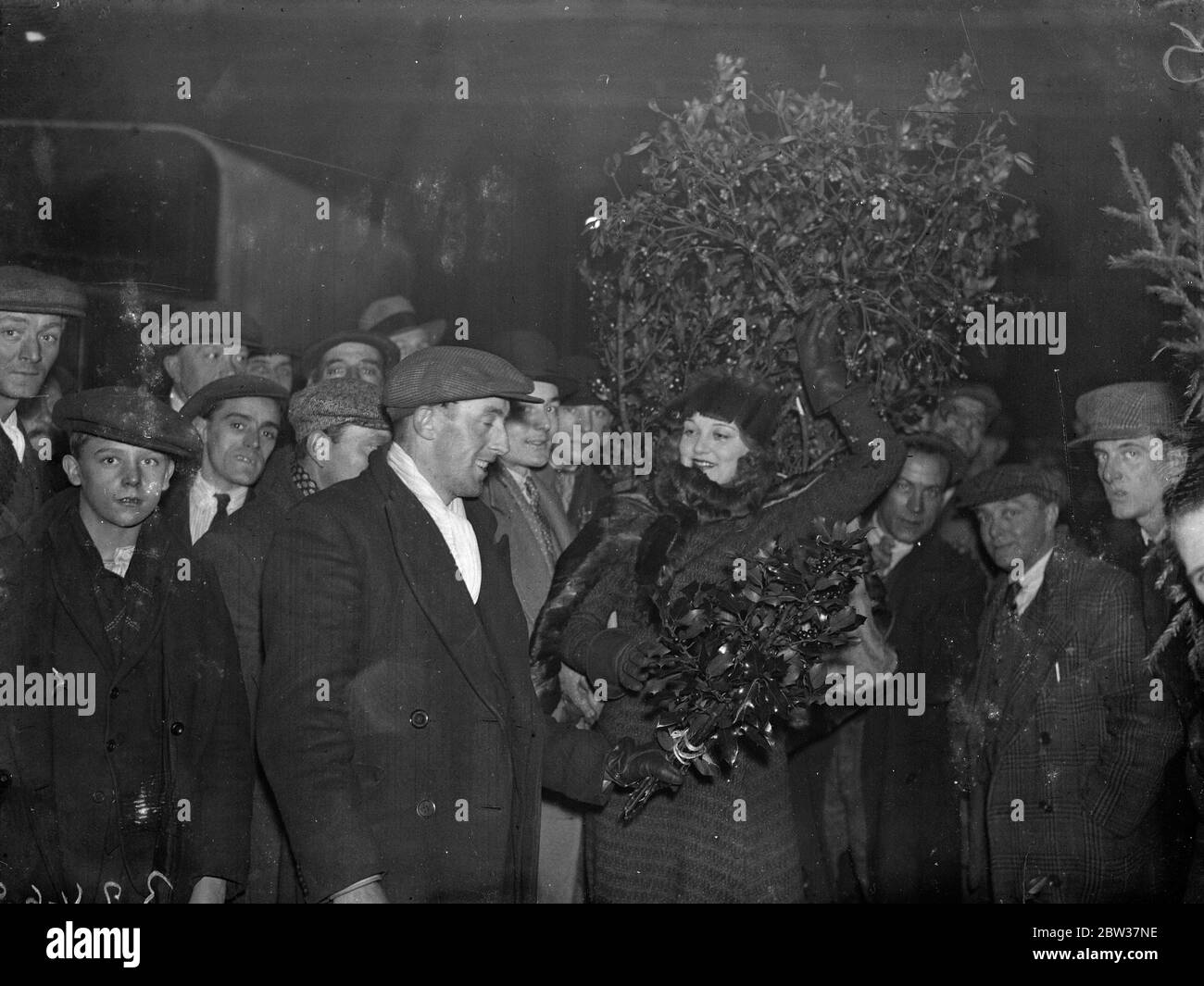 A shopping  attraction  in Covent Garden . Miss Blossom Berncastle , who plays the leading part in the London production of  Alf 's Button  , embarked on an early morning shopping expedition in Covent Garden . Photo shows ; Miss Berncastle buying holly at a stall in Covent Garden . 20 December 1933 Stock Photo