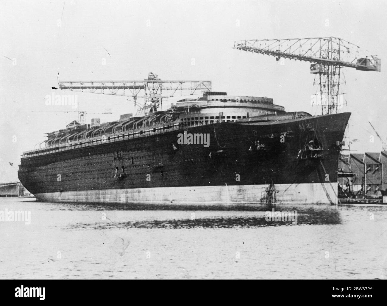 Giant French liner nears completion , Money difficulties which were overcome . The giant French liner ' Normandie ' , the construction of which was held up for a time by financial difficulties , is now nearing completion in the St Nazaire shipyards . She will be a formidable rival to the new Cunarder ' 534 ' . Photo shows : The new liner ' Normandie ' at St Nazaire . 22 December 1933 Stock Photo