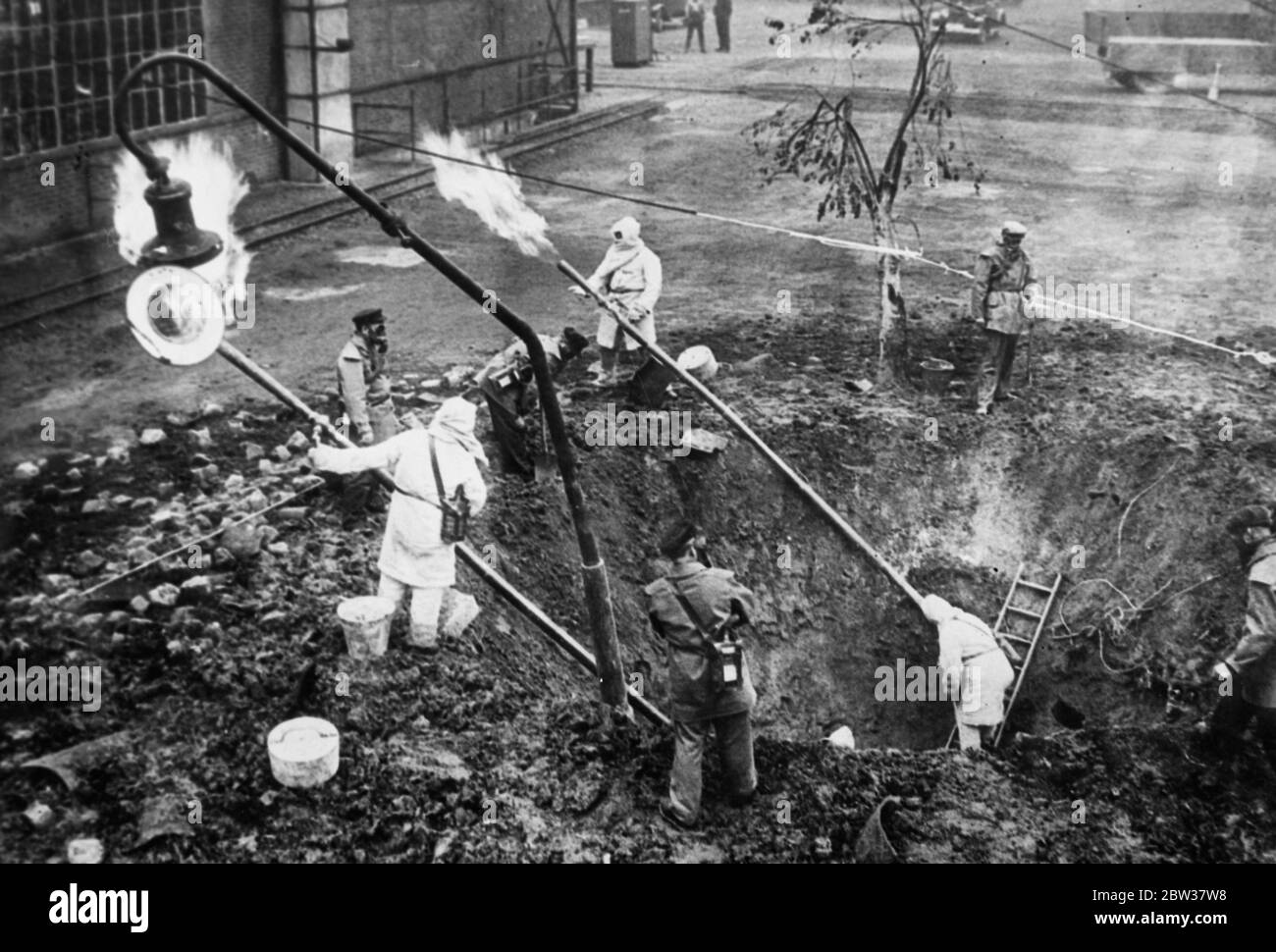 If there is ever an air raid on Berlin the gas works men will no what to do . Men at the Berlin gas works received training in methods of combatting attacks from the air in times of war . How gas escaping from a hole made by a bomb can be caught , passed through tubes and burned safely . Photo shows ; Men of the Berlin gas works demonstrating how escaping gas can be dealt with after an air raid . 27 November 1933 Stock Photo