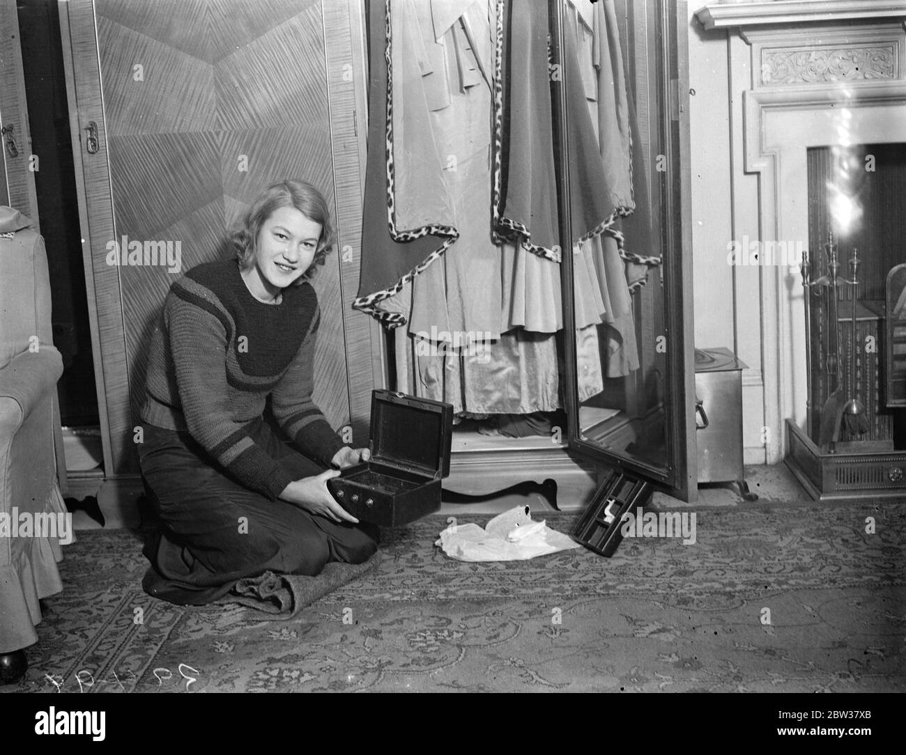 Cat burglar 's £7,000 jewel haul at London house . A cat burglar who broke in to the house of Mr Percy G Mayer at Cadogan Square , Chelsea , got away with over £7, 000 worth of jewelry . The robbery was carried out after an astonishing feat of agility . The gems were taken from jewel cases hidden in the bottom of the wardrobe . The robbery was discovered by Miss Veronica Brasch , a friend of the family . Photo shows ; Miss Veronica Brasch with the empty jewel cases which were hidden in the bottom of the wardrobe . 22 December 1933 Stock Photo