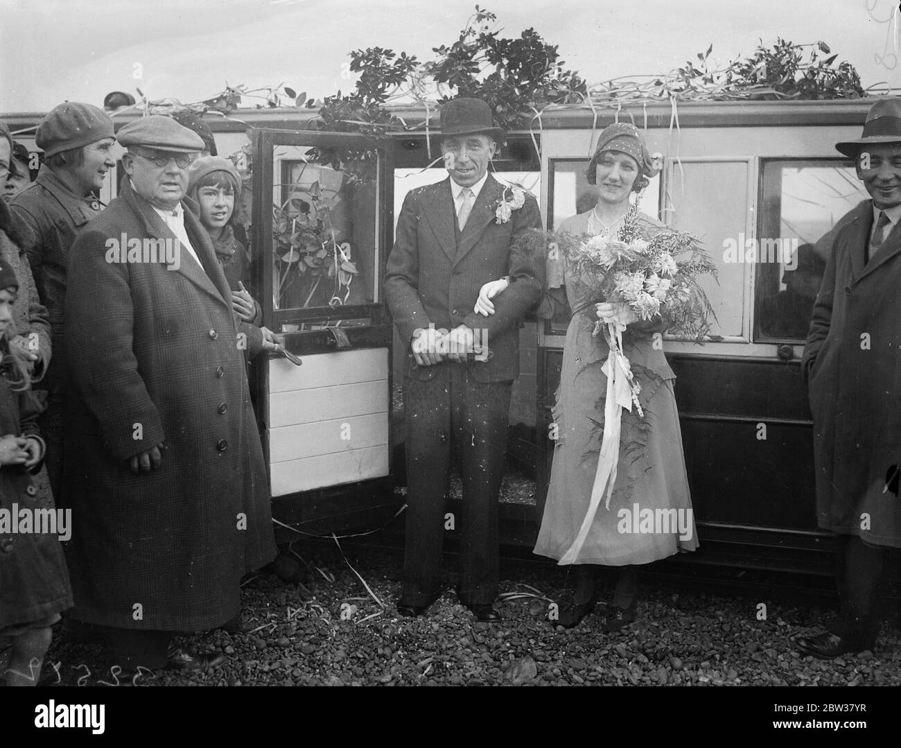 Special train for a bride . Railway re - opened for wedding of daughter of Dungeness fisherman . The bride travelled in a special train to and from her wedding when the little railway at Lydd , Kent , was opened specially for the wedding of Miss Annie Elizabeth Young , daughter of a Dungeness fisherman and her bridegroom , Mr Ambrose Bingham . The only means of transport between Miss Young 's home and Lydd , 3½ miles distant , is the little railway , which crosses two miles of shingle . Photo shows ; The bride and groom about to enter the carriage of the Little Train after the ceremony . 23 De Stock Photo