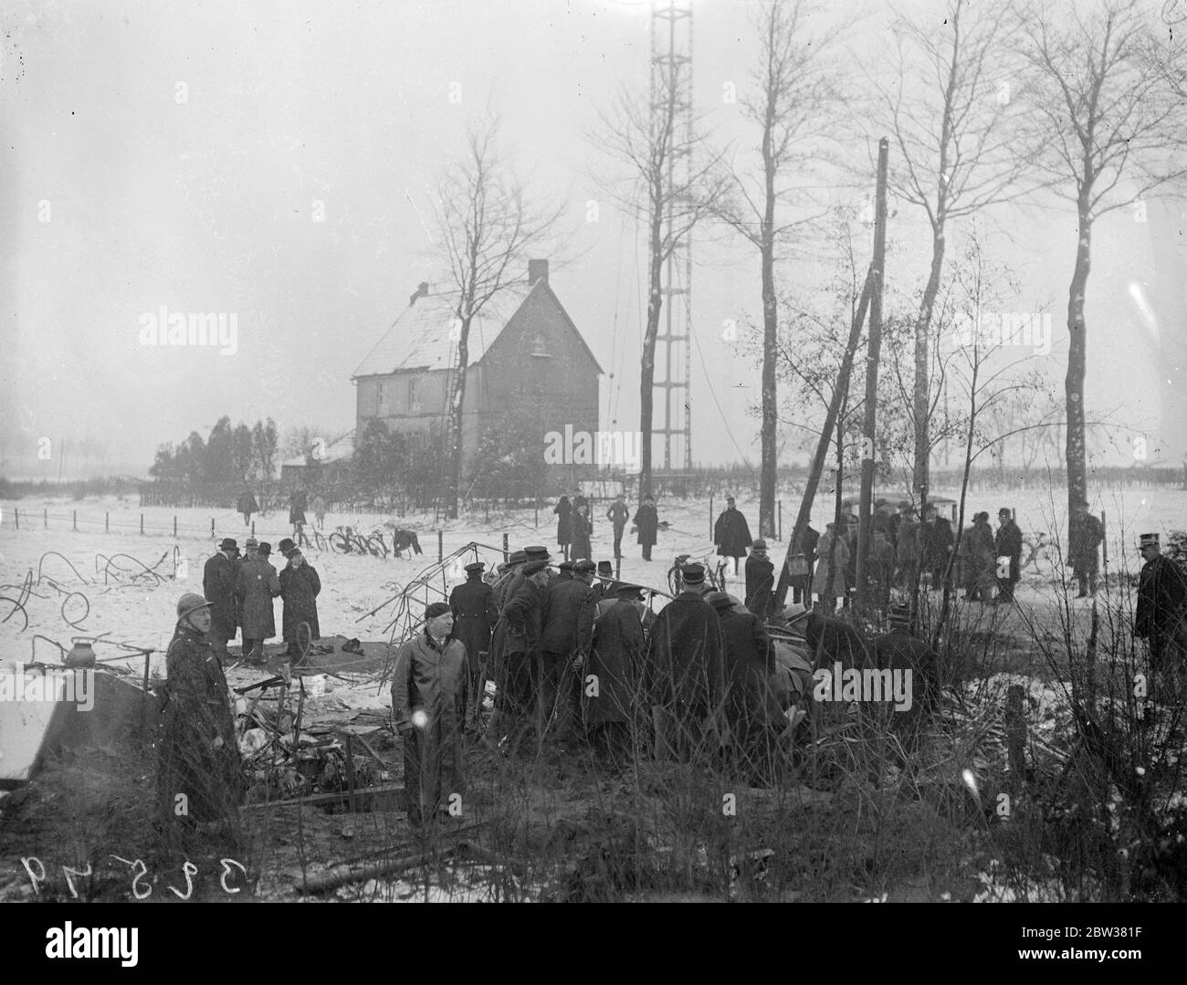Ten killed in British airliner crash . Eight passengers , the pilot and first officer were killed when the Imperial Airways airliner , Apollo  , flying from Brussels to London , crashed into the aerial mast of the Ruysselde Radio Station , near Bruges , Belgium and burst into flames . Photo shows ; People searching the wreckage of the crashed plane . 31 December 1933 Stock Photo