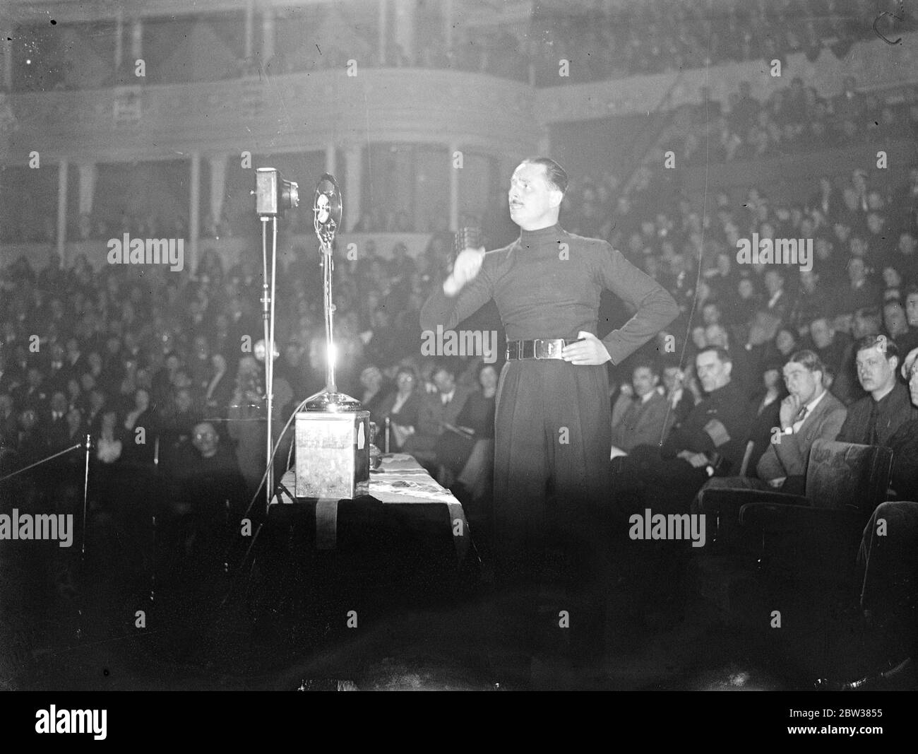 Mr Oswald Mosley makes a dramaic call to Britain in great meeting of ten thousand of his followers in the Royal Albert Hall , London . The Albert Hall , Kensington , the largest hall in the country , was filled to over flowing with ten thousand people who have an enthusiastic welcome to Sir Oswald Mosley , the British Blackshirt leader who stated his policy in a dramatic call to Britain ' to give all , and dare all for England ' . He called for a Government Motion , and air equality with the strongest Power in Europe , with no international aggression . Photo shows , Sir Oswald Mosely addressi Stock Photo