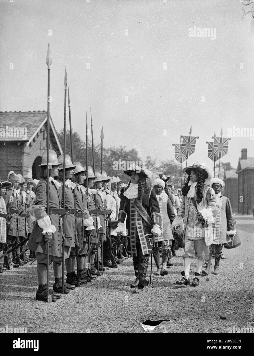 Historical uniforms issued to troops for Aldershot tattoo . Historical uniforms and costumes embracing representations from the reign of James II to full dress uniforms worn by the Indian Army of the present day were issued at Albuhera Drill Hall , Aldershot , to troops taking part in this year ' s Aldershot Tattoo . An inspection was held afterwards . Photo shows , James II ( right ) and William III inspecting the Tattoo uniforms . 12 May 1934 Stock Photo