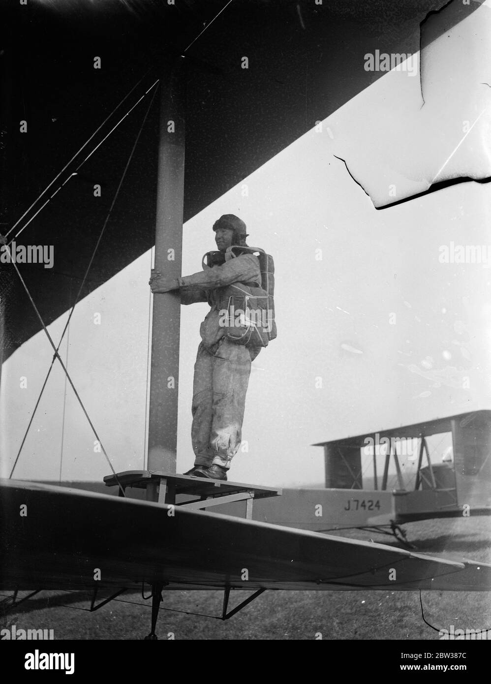 RAF parachute test section at work . A demonstration was given at the Royal Air Force parachute section at Henlow Aerodrome , Bedfordshire , of the work and training of parachutists . Testing parachutes is one of the items open to inspection by the public on Empire Air Day May 24 . Photo shows , a parachutist takes position on a jump platform holding onto the wing spar of a Vickers 'Virginia' parachute training aircraft . 10 May 1934 Stock Photo