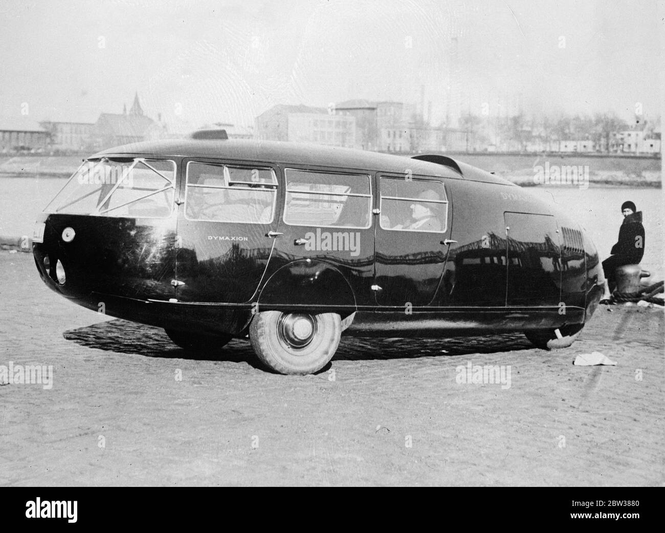 The car of the future . A three wheeled car with the appearance of an elongated black raindrop called the Dymaxion has been invented by Buckminster Fuller , an American . it is streamlined , has two front wheels set mid way in the ovaloid body and one rear wheel , set in the tail . The rear wheel steers the car , acting precisely as does the rudder of a ship . The car is capable of a speed of 125 miles an hour . A periscopic device supplies the usual rear vision mirror . The motor is mounted in the rear , but drives the front wheels . Photo shows , the Dymaxion . 11 May 1934 Stock Photo