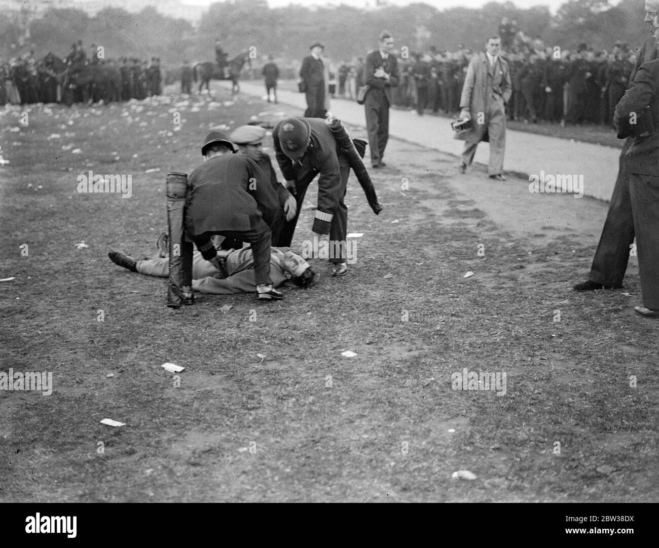 Police struggle with crowd at fascist demonstration . Police struggle to hold a huge crowd in check when Mr Oswald Mosley , leader of the British Union of Fascists , arrived in Hyde Park to address the fascist demonstration . Police struggling to hold back the crowd as Sir Oswald Mosley arrived . 9 September 1934 Stock Photo