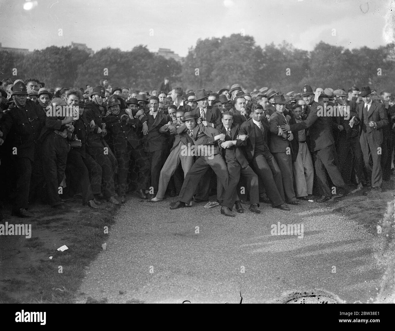 Police struggle with crowd at fascist demonstration . Police struggle to hold a huge crowd in check when Mr Oswald Mosley , leader of the British Union of Fascists , arrived in Hyde Park to address the fascist demonstration . Police struggling to hold back the crowd as Sir Oswald Mosley arrived . 9 September 1934 Stock Photo
