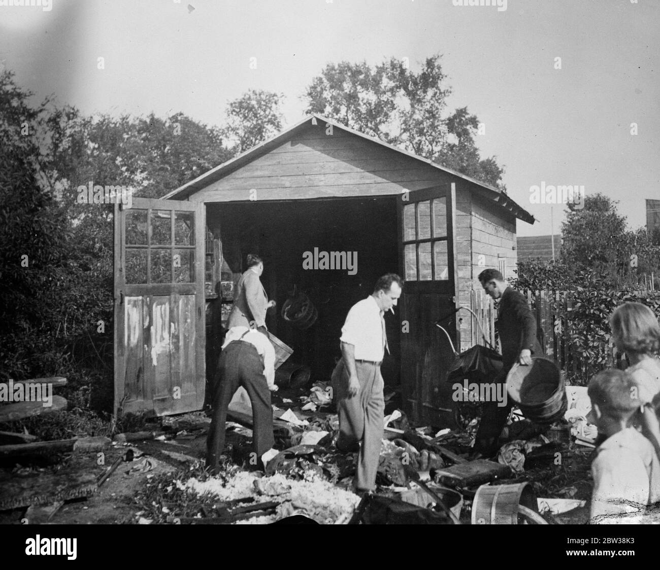 Ransom money for Lindbergh baby found in garage in Bronx district , New York . Kauptman arrested . Photo shows , men searching outside the garage in the Bronx , New York , where part of the Lindbergh ransom was found . 28 September 1934 Stock Photo