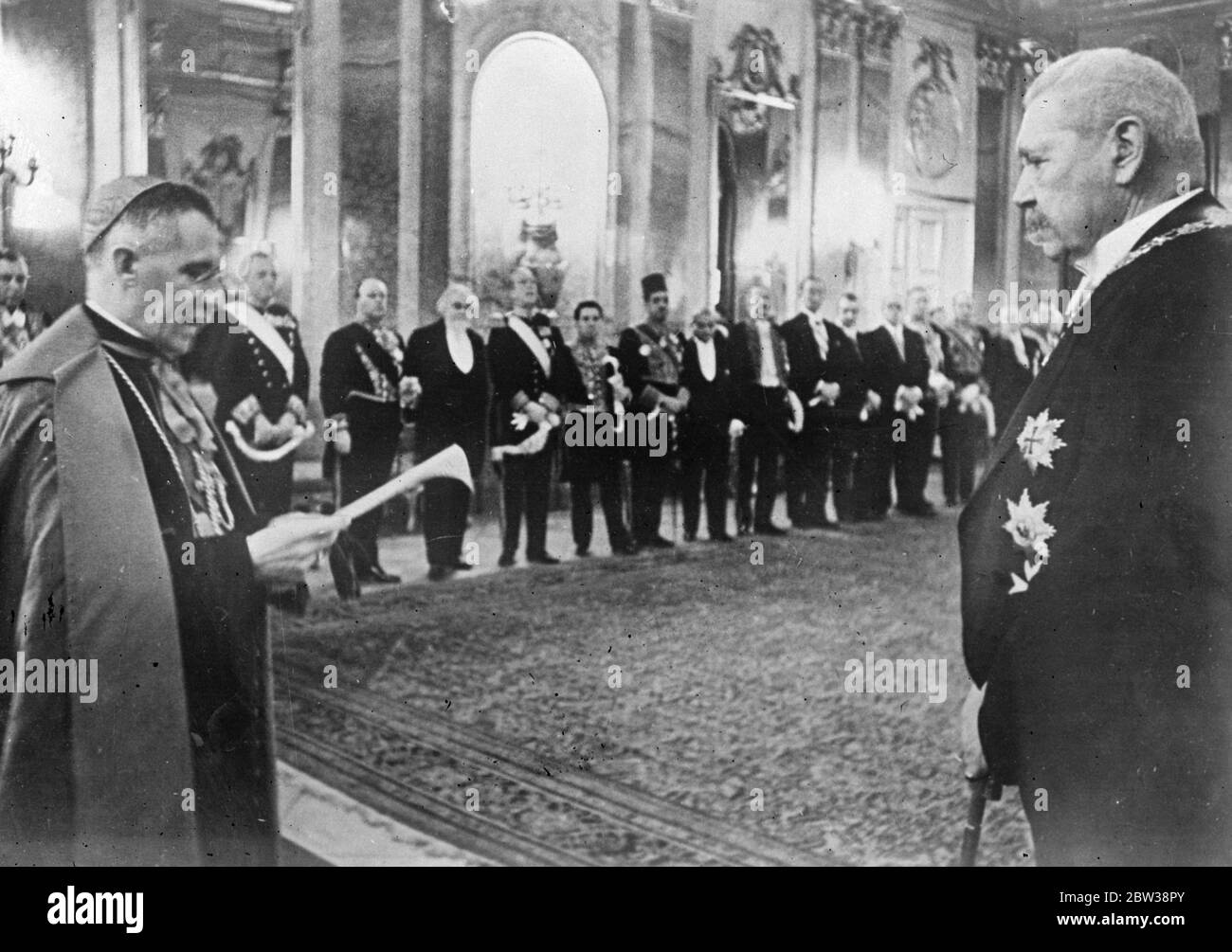 Diplomatic Corps ' New Year greetings to President Von Hindenburg . Members of the Diplomatic Corps in Berlin visited the Presidential Palace to convey New Year greetings to President von Hindenburg , at the customary reception . Photo shows ; President von Hindenburg listening to the speech of New Year greetings read by the doyen of the Diplomatic Corps , Monseignor Orsenigo , Papal Nuncio . 3 January 1934 Stock Photo