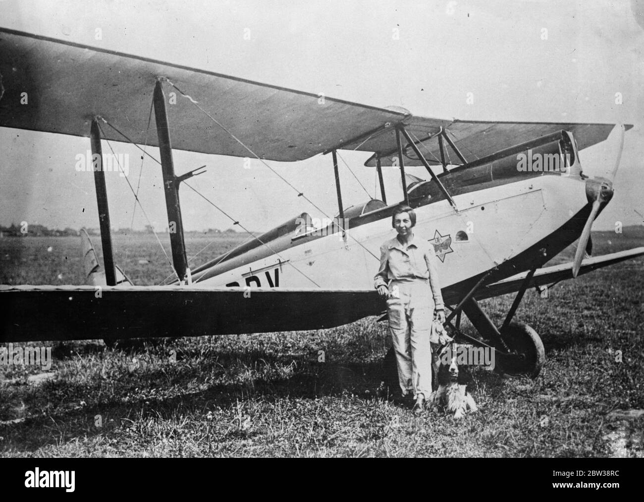 Miss Evelyn Frost, an American airwoman , was burnt to death when her Moth ' plane crashed at Nevers , France. The pilot , Geoffrey Ruddle , a young Englishman, escaped serious injury. Photo shows ; Miss Evelyn Frost with her pet dog before the crash . 6 January 1934 Stock Photo