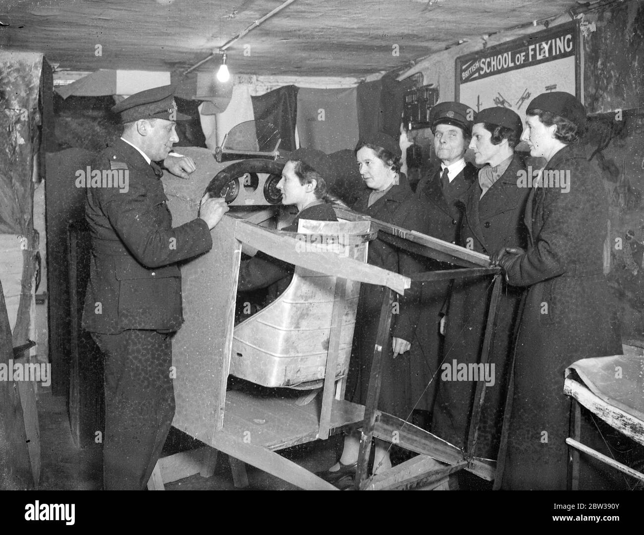 New Women ' s Reserve study ' s aviation . The recently formed Women ' s Reserve , organised by Commandant Mary Allen , is undergoing aviation instruction by skilled officers of the new British Flying Corps . The reserve recruits are given a strict curriculum of drills and lectures . Photo shows ; a class under instruction in the theory of flight at the headquarters in Peckham , London . 12 January 1934 30s, 30's, 1930s, 1930's, thirties, nineteen thirties Stock Photo