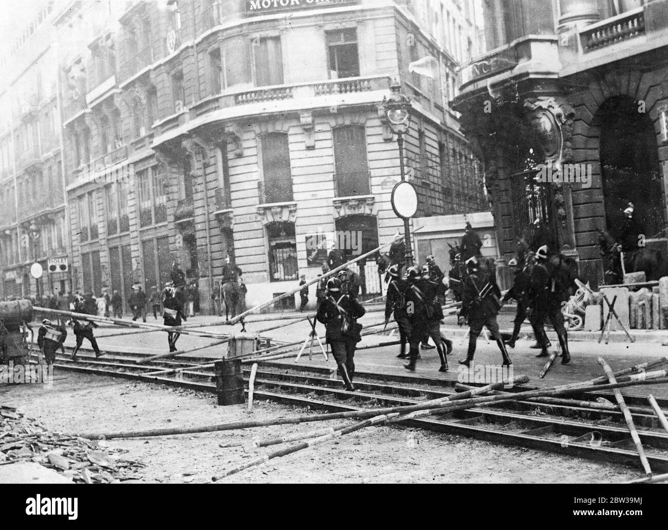 More than a thousand arrests in Paris anti wage cut riots - police in fierce battles with demonstrators . Mobile Guards storming barricades erected by demonstrators in the Rue Lafayette . 20 July 1935 Stock Photo