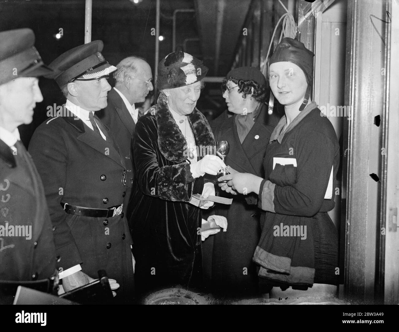 Women ' s reserve hold swimming gala . The women ' s reserve , the recently formed women ' s force under the command of Commandant Mary Allen , held a swimming gala at the Great Smith Street baths , London . Photo shows , Lady Bertha Dawkins presenting a cup to Miss E Pascall , winner of the Ladies open 100 yards handicaps , on the left is Commandant Mary Allen , O B E . 20 April 1934 . Stock Photo