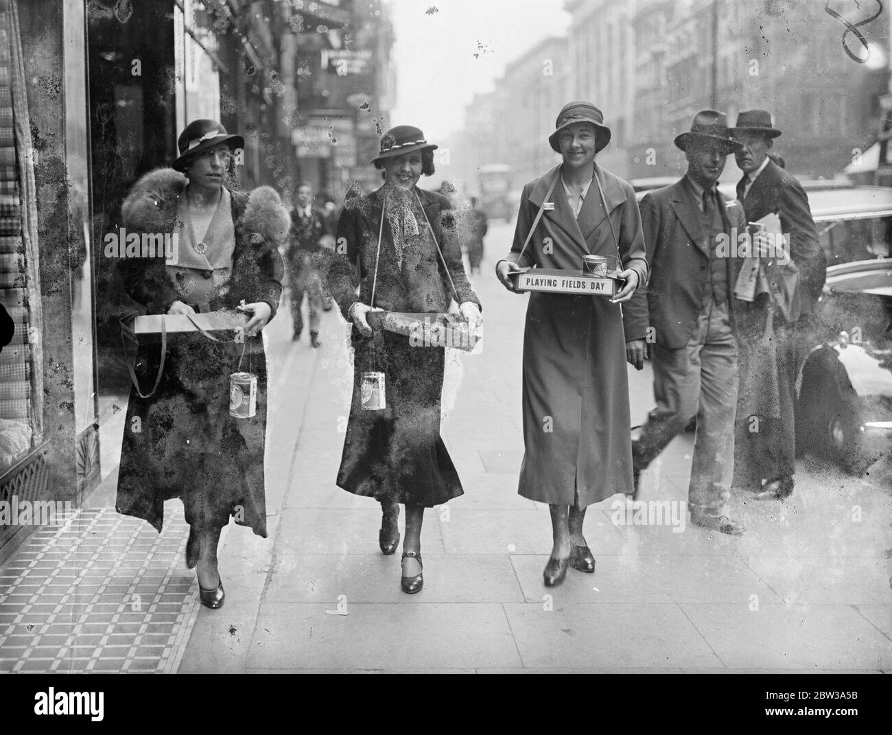 Rugby internationals ' wives collect for more playing fields . ' Playing fields day ' to raise funds for more playing fields , was celebrated throughout Greater London . Many women famous in sporting , theatrical and society circles assisted in the collection . Photo shows the wives of three international rugby captains walking in the Oxford Street with their trays , left to right , Mrs W J H Davies , wife of the former England captain , Mrs A L Gracie , wife of the former Scottish Captain and Mrs W W Wakefield , wife of another former England captain . 17 January 1934 Stock Photo