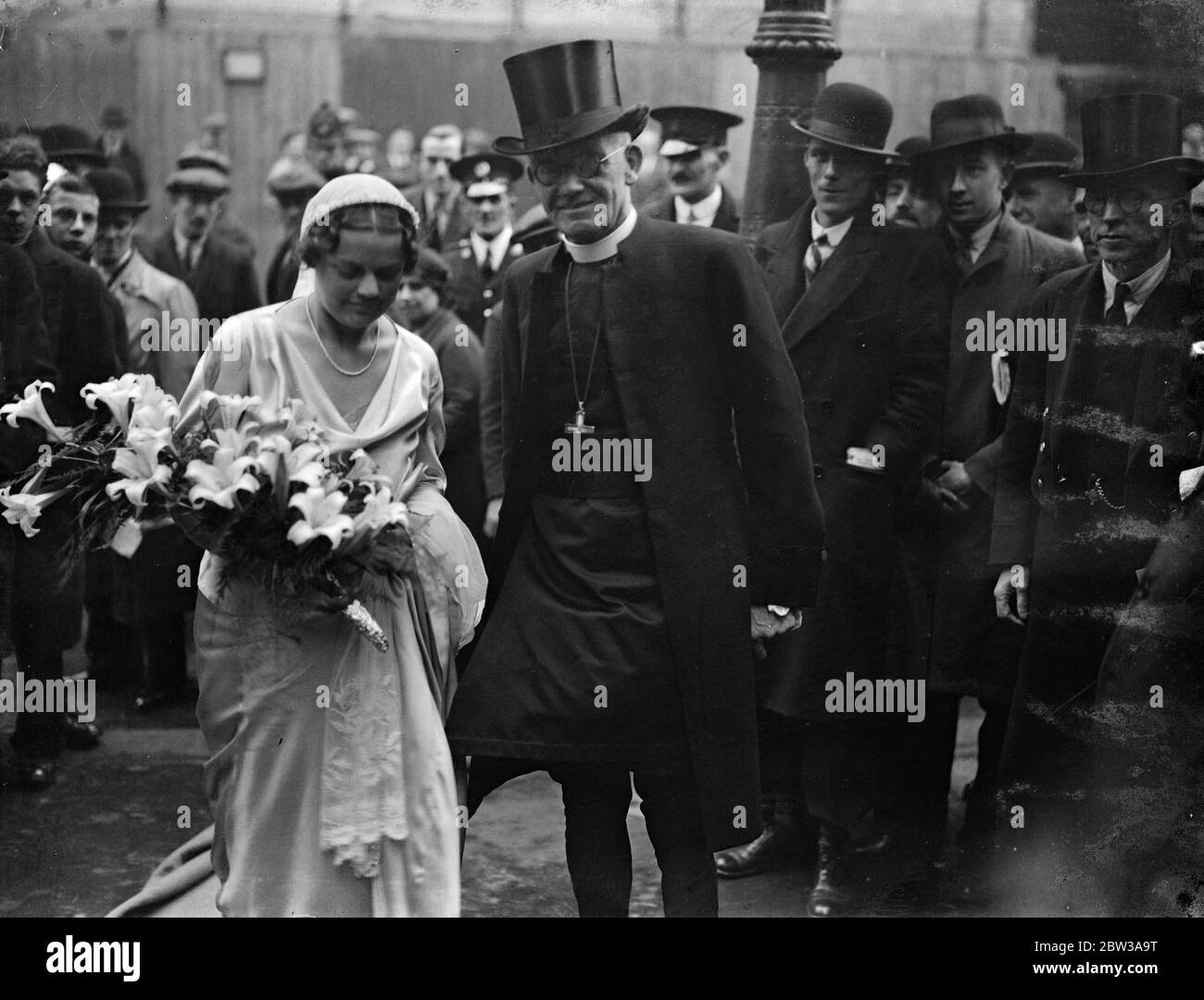 Three bishops at wedding of bishops daughter to bishop ' s son . Three bishops took part in the wedding at St Margaret ' s Church , Lothbury , City , of Miss Nancy Curzon , daughter of the Bishop of Stepney , to Mr Michael Willcox Perrin , son of the Assistant Bishop of London . The Bishop of London ( Dr Ingram ) with Bishop Perrin took the service , and the Bishop of Stepney gave his daughter away . Photo shows the bride and groom . 12 April 1934 Stock Photo