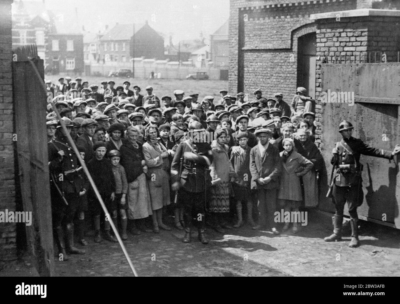 43 perish in Belgian mine disaster . Forty three men entomed when a disastrous explosion occured in a coal mine near Paturages , Belgium . The explosion occured in a gallery 2 , 700 feet underground . After the accident the mine was sealed . Photo shows armed police holding back the crowd of anxious relatives waiting for news at the gates . 17 May 1934 . Stock Photo